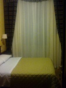 ローマにあるPitagora Houseのベッドルーム1室(ベッド1台付)、窓(カーテン付)