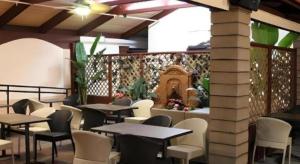 ein Restaurant mit Tischen und Stühlen und einem Kamin in der Unterkunft Alhambra Hotel in Alhambra + 70 Fotos