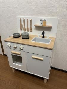 a miniature kitchen with a sink and utensils at Biei Relax Stay B in Biei