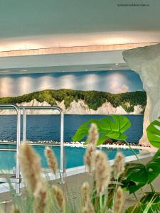a wall with a painting of a view of the ocean at Rügen-Hotel in Sassnitz