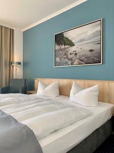 een groot wit bed in een hotelkamer bij Rügen-Hotel in Sassnitz
