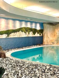 a painting of a swimming pool next to the water at Rügen-Hotel in Sassnitz +30 photos