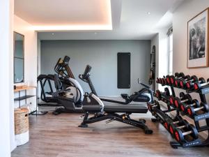 een fitnessruimte met cardio-apparatuur in een kamer bij Hotel Mercure Parc du Coudray - Barbizon in Le Coudray-Montceaux