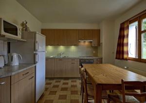 a kitchen with a wooden table and a white refrigerator at Drelo 1 in Verbier