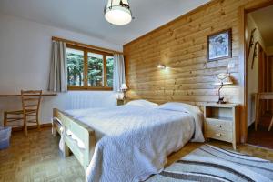 - une chambre avec un lit et un mur en bois dans l'établissement Drelo 1, à Verbier