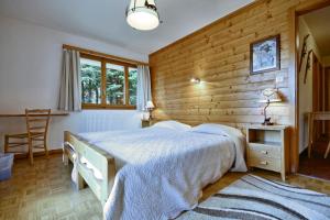 a bedroom with a bed and a wooden wall at Drelo 1 in Verbier