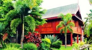 une maison rouge avec des palmiers devant dans l'établissement Umphangburiresort, à Umphang