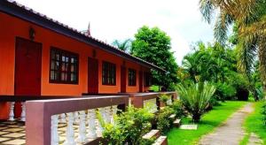 un bâtiment orange avec une clôture devant dans l'établissement Umphangburiresort, à Umphang 87 autres photos