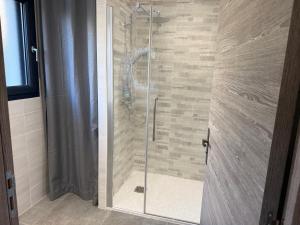 a shower with a glass door in a bathroom at The Eagle's Nest - cosy chalet for two in Jarjayes +10 photos