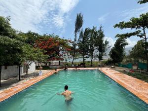 a man in the water in a swimming pool at Dongre's Farm, Malshej Ghat in Junnar