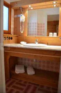 a bathroom with a sink and a mirror and towels at Hotel Floralp in La Clusaz