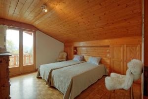 a bedroom with two beds and a large window at Drelo 3 in Verbier