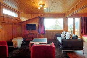 a living room with a couch and a tv at Drelo 3 in Verbier
