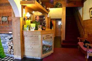 un hombre parado detrás de un mostrador en una habitación en Hotel Floralp, en La Clusaz