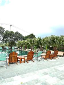 a row of chairs and a table next to a pool at Lona Villa Tam Coc in Vũ Lâm