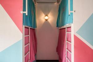 a hallway with pink and blue curtains and a light at Divas Hostels in Ahangama