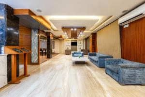 a living room with blue couches and a table at The Global Hotel by Platinum I 100m Medanta Hospital I Sector-38 I Gurgaon in Gurgaon