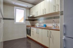 een keuken met witte kasten en een raam bij Apartman -PANORAMA LUX in Sutomore