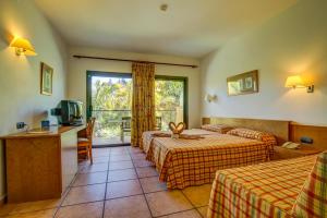 a hotel room with two beds and a television at SBH Club Paraiso Playa in Playa Jandia +40 photos