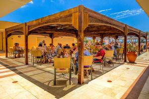 a group of people sitting at a restaurant under a pavilion at SBH Club Paraiso Playa in Playa Jandia
