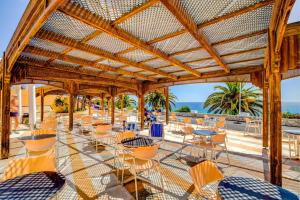 a patio with chairs and tables and the ocean at SBH Club Paraiso Playa in Playa Jandia