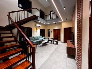 een woonkamer met een trap en een bank bij Tamizh Agam in Ramanathapuram