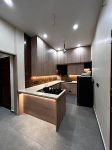 een keuken met een spoelbak en een zwarte koelkast bij Tamizh Agam in Ramanathapuram