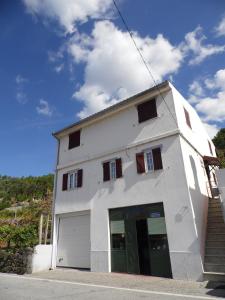 ein weißes Gebäude mit einer Garage auf einer Straße in der Unterkunft Casa do Limoeiro 2 in Valezim