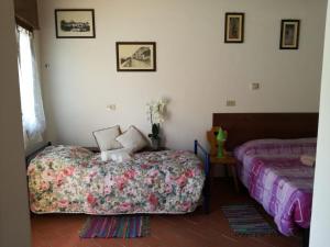 a bedroom with two beds and a table with flowers at Locazione da nonna Gusta in Vittorio Veneto