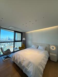 una camera da letto con un letto bianco e una grande finestra di Caelum Black Gangnam Luxury Apt 카일룸블랙 강남 럭셔리 아파트 a Seul