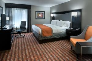 a hotel room with a bed and a desk and chair at Holiday Inn Express & Suites Nashville Southeast - Antioch, an IHG Hotel in Antioch