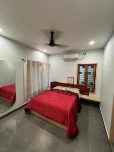 een slaapkamer met een rood bed en een raam bij Tamizh Agam in Ramanathapuram
