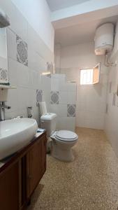 a bathroom with a white toilet and a sink at Villa mit Pool in Mbour in Mbour