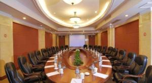 een grote conferentieruimte met een lange tafel en stoelen bij Hubei Poly Hotel in Wuhan