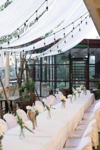 a long table with white chairs and a white tent at River Jam Amphawa in Amphawa