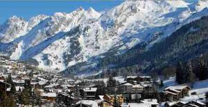 una ciudad frente a una montaña cubierta de nieve en Hotel Floralp, en La Clusaz 22 fotos más