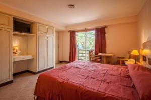 a bedroom with a large red bed and a window at Apart Carilo Palace in Carilo +34 photos