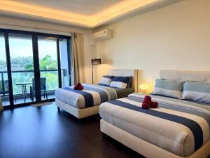 a hotel room with two beds and a couch at R&F Princess Cove JB Apartment Suites By SC Homestay in Johor Bahru +230 photos