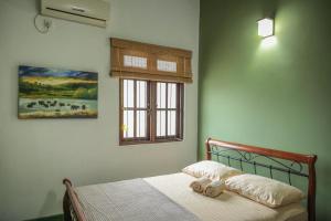 a bedroom with a bed with a window and a picture at Self Cate Luxury Apartments in Kandy