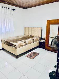 a bedroom with a bed and a desk and a mirror at JHome in Kurunegala