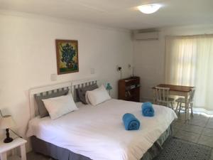 um quarto com uma cama com almofadas azuis em Mopani Cottage em East London