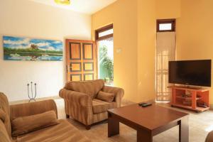 a living room with two chairs and a flat screen tv at Self Cate Luxury Apartments in Kandy