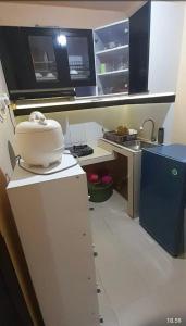 a small kitchen with a white appliance on a counter at Arsya kost homestay in Balikpapan +8 photos
