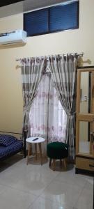 a room with a bed and a window with curtains at Arsya kost homestay in Balikpapan
