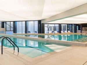 een groot zwembad in een gebouw met glazen ramen bij ibis styles La Rochelle Thalasso Chatelaillon in Châtelaillon-Plage