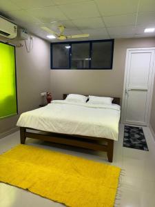 a bedroom with a bed and a yellow rug at Jp Resorts in Muttupet