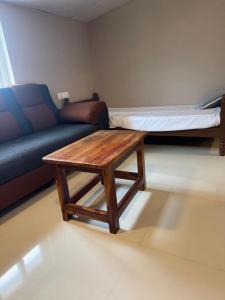 a living room with a couch and a wooden coffee table at Jp Resorts in Muttupet +6 photos