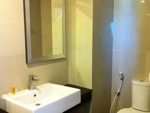 une salle de bains avec lavabo, toilettes et miroir dans l'établissement Hotel Benua, à Pulupanda 164 autres photos