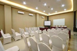 een conferentieruimte met witte stoelen en een scherm bij Hotel Betha Subang in Subang
