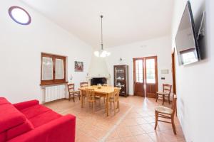 een woonkamer met een rode bank en een tafel bij Villa Letizia in Scorrano
